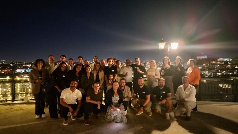 Large group of Cybertech founders and guests at an evening gathering overlooking a city